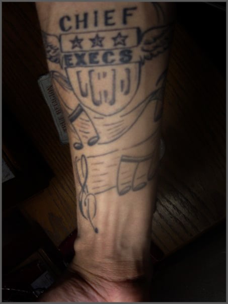 Chief Execs crest tattooed on a forearm